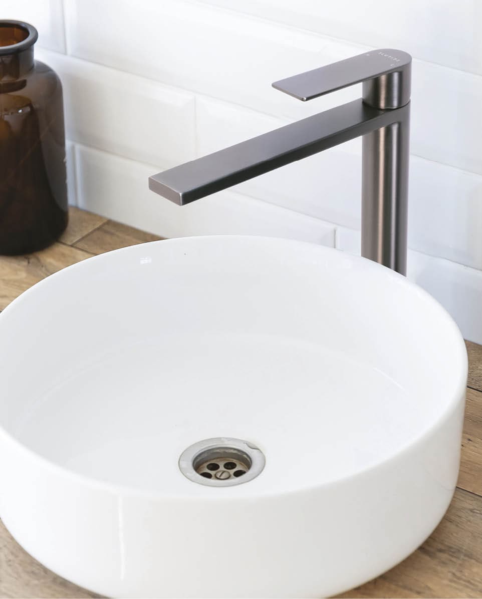Black faucet for water and white separate high sink on wooden pedestal, top view. Loft style bathroom.